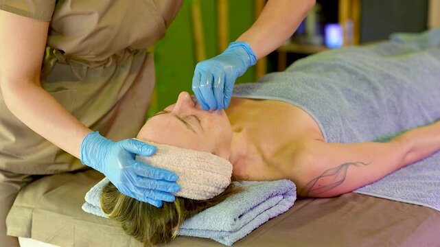 Anti aging buccal facial massage wearing disposable gloves. Intraoral sculpting technique for release facial muscle tension, improve contour, support lymphatic drainage, promote natural lifting.