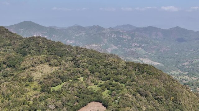 Green top of mountain with forest aerial drone view