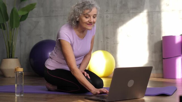 Senior woman finishing online yoga class at home