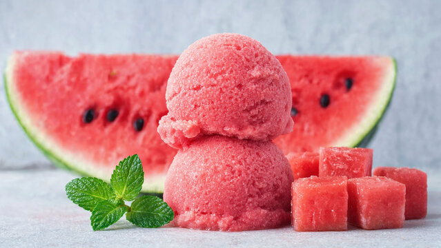 Watermelon sorbet scoops with fruit cubes, mint garnish on stone surface, summer frozen dessert, picnic menu, barbecue sweets, pool party treats, fruit recipe, granita texture, shaved ice