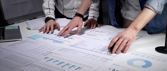 Business professionals analyzing financial data and market trends, reviewing growth charts, and...