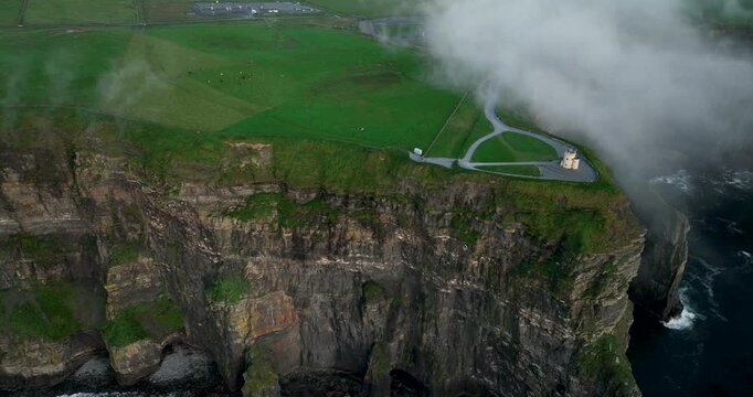 Aerial drone pullback and ascent revealing O'Brien's Tower on Cliffs of Moher, Ireland