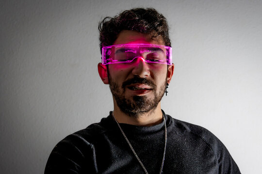 Man wearing glowing cyberpunk glasses experiencing virtual reality and metaverse tech