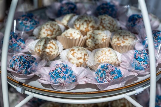 Sweet treats are arranged on a serving tray at a festive gathering with brigadeiro as the main dessert