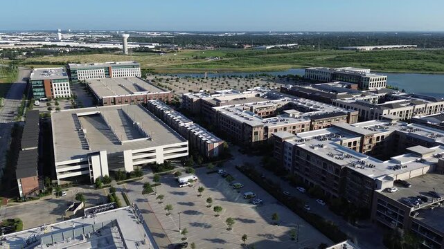 Brick clad corporate buildings mark edge of busy business development zone near major transit routes. Intelligent site planning maximizes available land for growth parking throughout Coppell, TX
