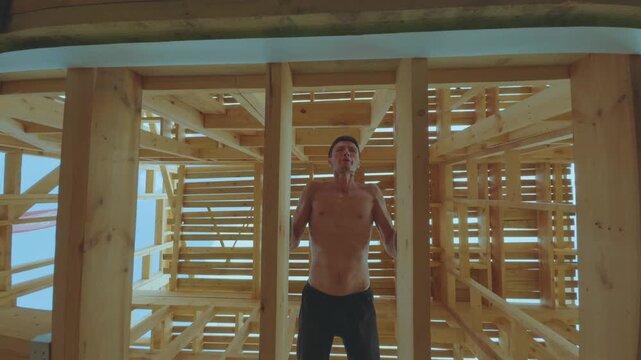 A man does push-ups in a building under construction