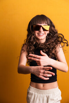 Young woman dancing with confidence wearing stylish shades