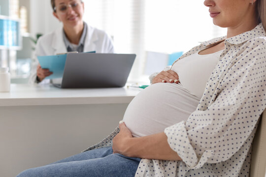 Pregnant woman having appointment with doctor in clinic, closeup