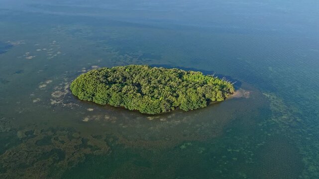 Island in sea. Green island surrounded by sea. Aerial landscape view on island in ocean. Travel and tourism. Traveling and adventure