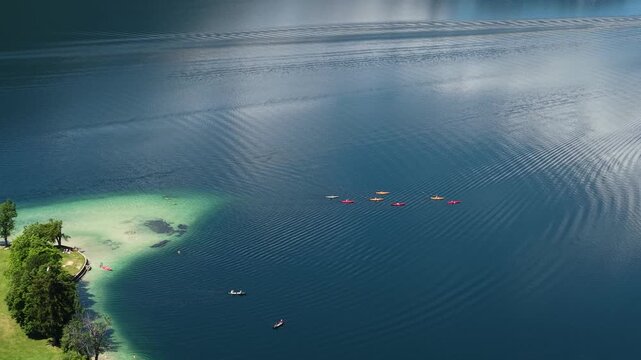 Drone Shot of Kayakers in Blue Water of Lake Bohinj Slovenia on Sunny Summer Day
