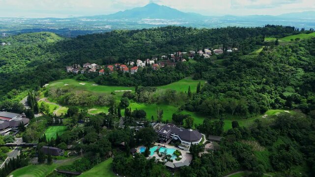 Wide establishing aerial shot of The Country Club at Tagaytay Highlands in Talisay Batangas Philippines showcasing an exclusive luxury country club surrounded by expensive residential area.