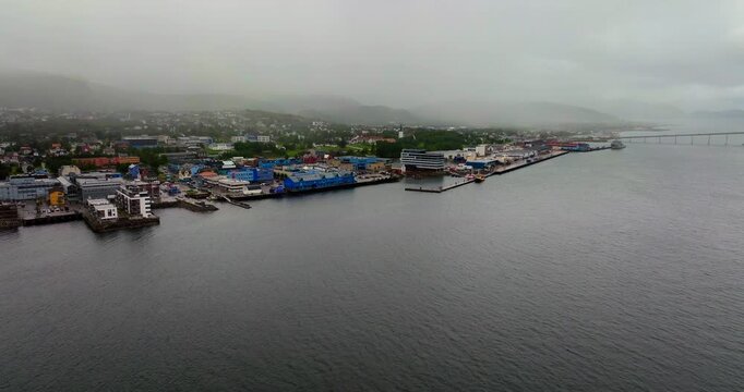 Aerial view over Sortland in Northern Norway, showing a misty coastal harbour, buildings, fjord scenery and waterfront infrastructure in the Vester&aring;len region