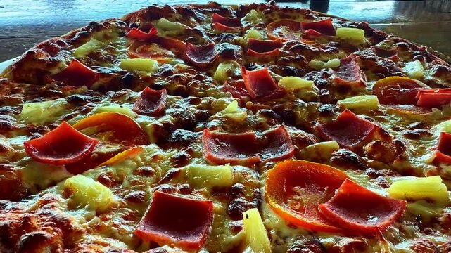Close-up of pizza topped with red peppers and pineapple slices.