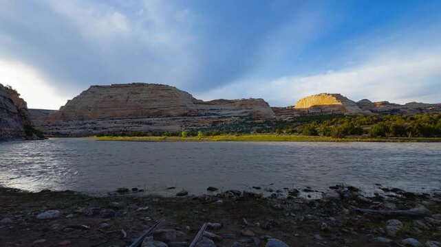 Harding Hole backcountry camping overlook spot, wide Yampa River with distant canyon hills beneath dramatic cloud streaks, wide static backdrop with nobody