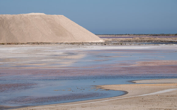 Pink salt pans, natural evaporation ponds, reflecting the late afternoon sun at salt works in Giraud, Camargue, Rhone delta, Provence, south of France.
