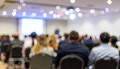 Fototapeta premium Conference room filled with professional people attending a corporate business seminar event with a blurred background and bright lights
