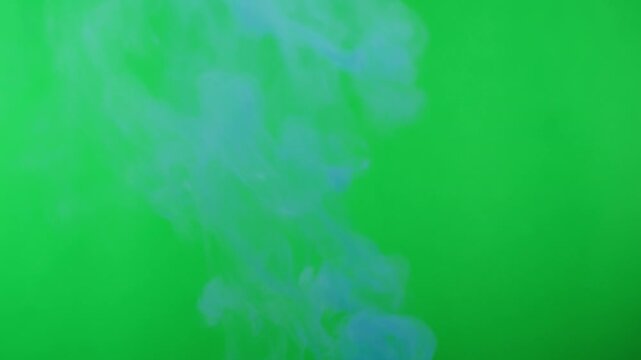 Blue smoke on green chroma key background. Smoking, steam clouds of vapour close-up. Burning, fog. 