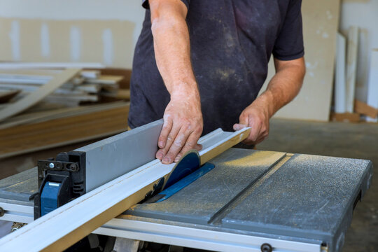 Worker uses table saw to cut wood in workshop