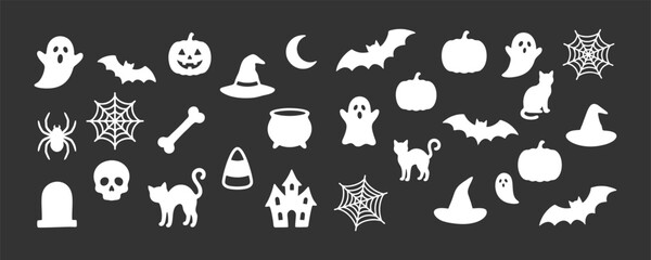 Fototapeta premium Collection of white halloween silhouette icons featuring ghosts bats pumpkins cats hats and spiders on a dark grey background surface