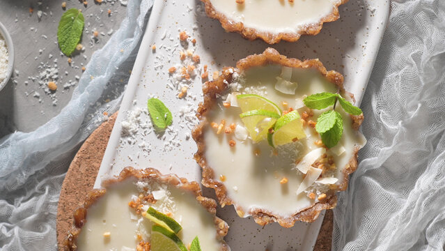 Mini lime and coconut tarts on a rustic serving platter