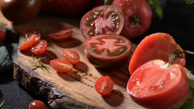 Freshly sliced organic tomatoes on a rustic wooden cutting board