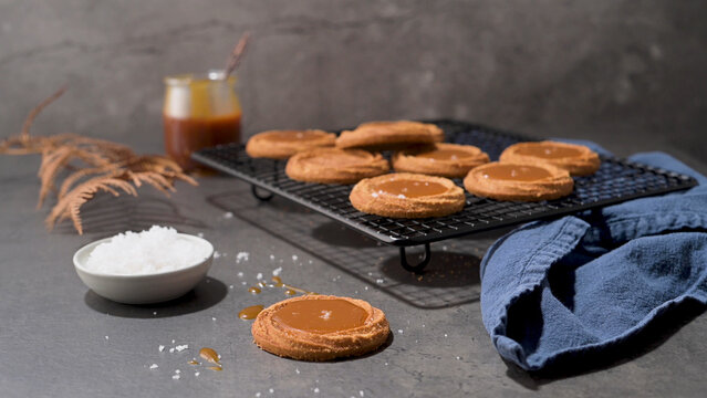 Salted caramel thumbprint cookies on a cooling rack