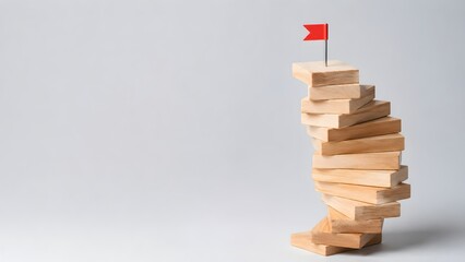 Obraz premium Red flag pin on top of stacked wooden block tower. Concept of career achievement, business goal leadership, and overcoming startup obstacles.
