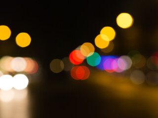 Out of focus street lights creating colorful circular bokeh patterns in the dark. © rizki.io_