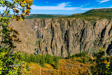 Autumn scrub oak frames the iconic dark canyon walls and Gunnison River far below, Black Canyon of the Gunnison NP, Colorado. © ZL Visuals