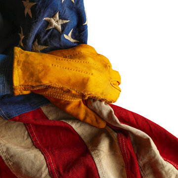 Worn work glove pulling back the American flag. Symbolic of blue collar workers, USA manufacturing, pride in products Made in United States of America, or to celebrate Father's day or US Labor Day.