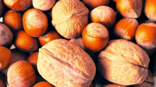 Top view close up of mixed whole walnuts and hazelnuts rotating