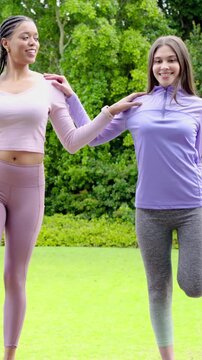 Vertical video: Balancing woman in purple moving to door in yard as friend letting go for balance