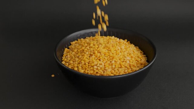 Full black bowl with yellow lentils dark background macro 4k