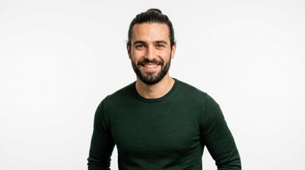 Fototapeta premium Happy young man with a beard and hair bun wearing a green sweater smiling at the camera on a plain white background