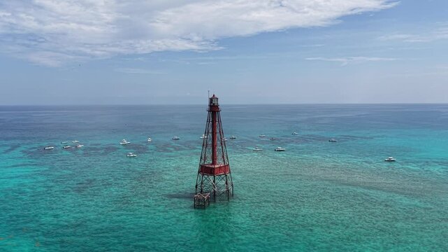 Boats moored on a beautiful day at Sombrero Key Reef Lighthouse near Marathon in the Florida Keys.
