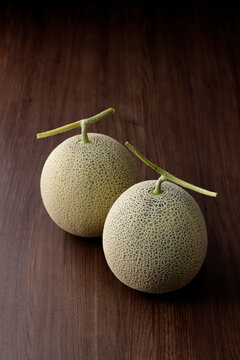 木目テーブルに置いた高品質な北海道産のメロン
High-quality Hokkaido melon on a wooden table,