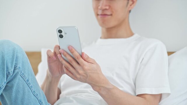 リラックスしてスマホを使う男性。アプリ、SNS、リラックス、ゲーム、メール、動画、DX、AI、通販