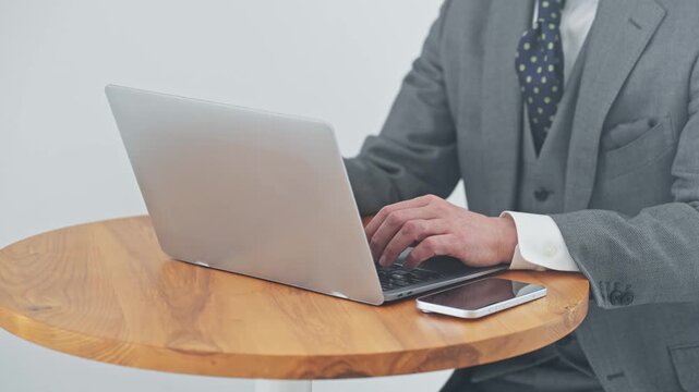 ノートPCを使う男性ビジネスパーソン。パソコン、ビジネス、仕事、DX、オフィス、デジタル、カフェ