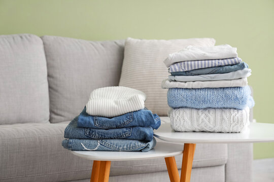 Stacks of clean clothes on tables in stylish living room