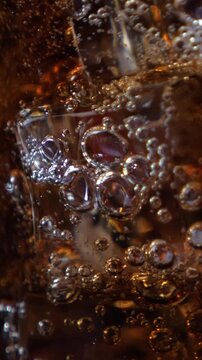 Fizzling cold beverage in the glass. Closeup. Vertical footage