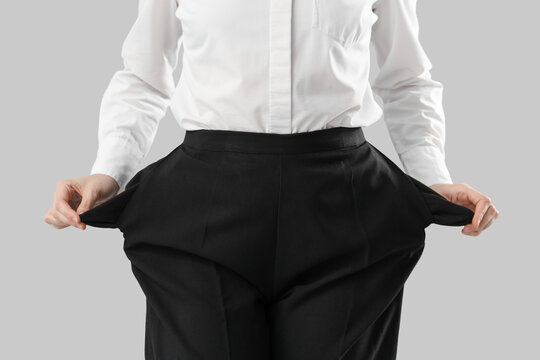 Bankrupt businesswoman with empty pockets on light background, closeup