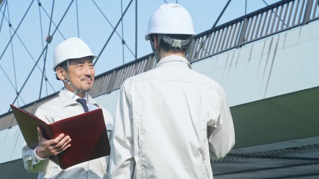 橋を点検する男性作業員のグループ。建設、保守、工事、安全、確認、インフラ、検査、調査、修繕、人材