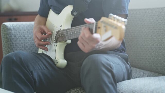 エレキギターを弾く男性。音楽、楽器、演奏、練習、趣味、バンド、音楽家、ミュージシャン、ギタリスト