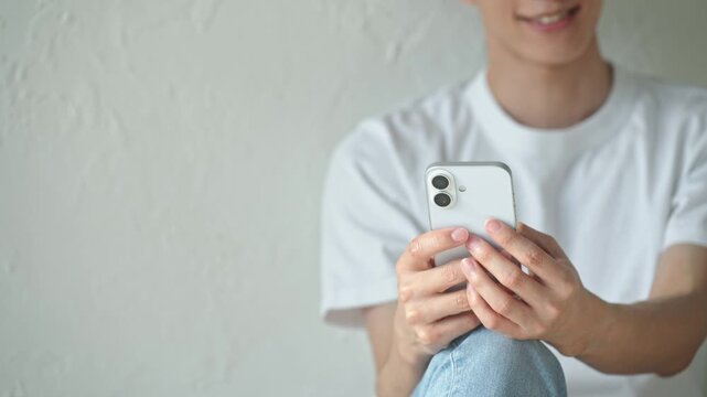 スマホを使う男性。アプリ、SNS、動画、メール、DX、ゲーム、リラックス、若者、検索、スマートフォン