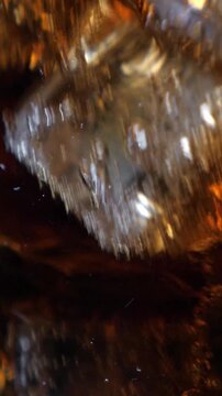 Fizzling cold beverage in the glass. Closeup. Vertical footage
