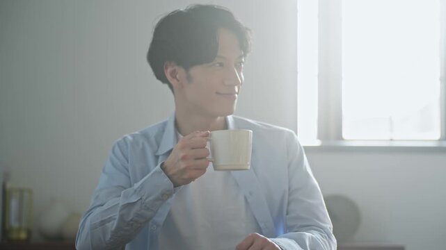 カフェでくつろぐ男性。コーヒー、紅茶、休憩、笑顔、自宅、一服、若い、カジュアル、爽やか、イケメン