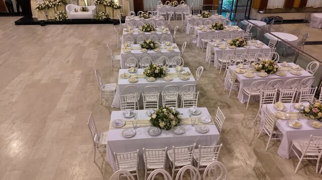Drone panning shot of a luxurious empty ballroom set up for a celebration event.
