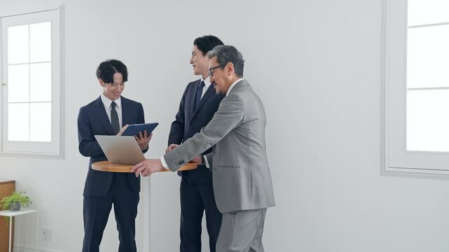 ノートPCを見ながら会話するビジネスパーソン。会議、チームワーク、グループ、ミーティング、人材、会社