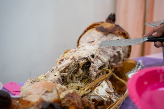 Close up of roasted whole pig being carved.