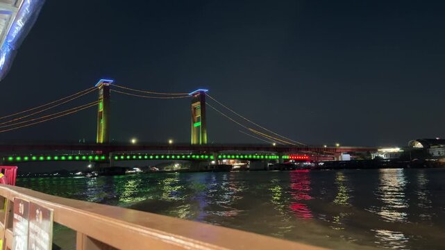 Ampera Bridge at night with green lights in Palembang, Indonesia